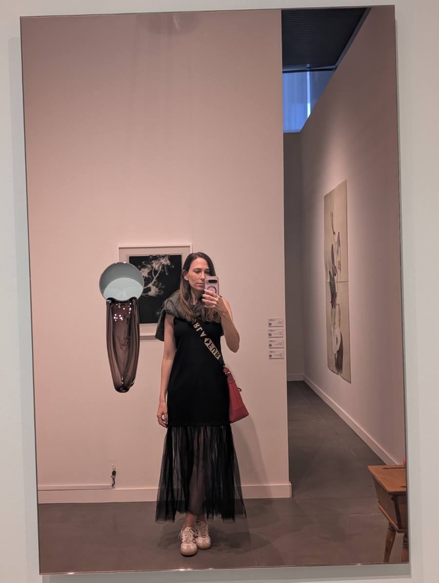 Stav reflected in a mirror artwork at a gallery