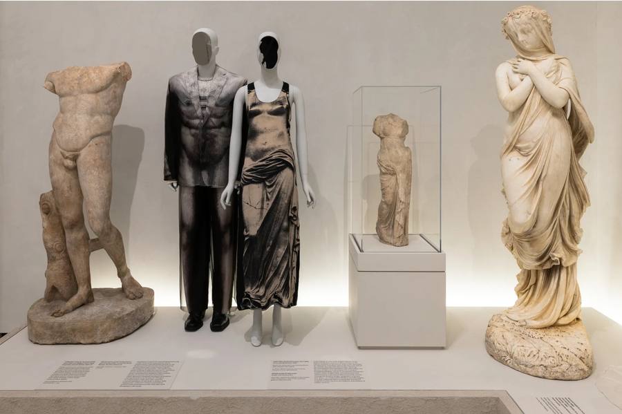Historic and contemporary dress shown beside classical sculpture at the Met