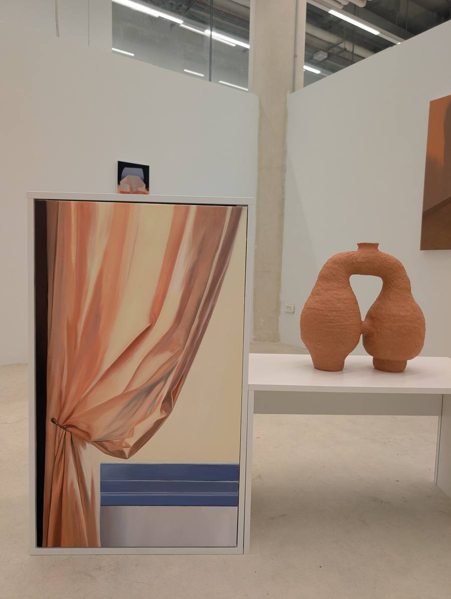 Installation view at the Bezalel graduate exhibition: Noa Wiegenfeld's painting of a peach curtain tied back with a ring above blue stripes, shown on a plinth beside a terracotta sculpture