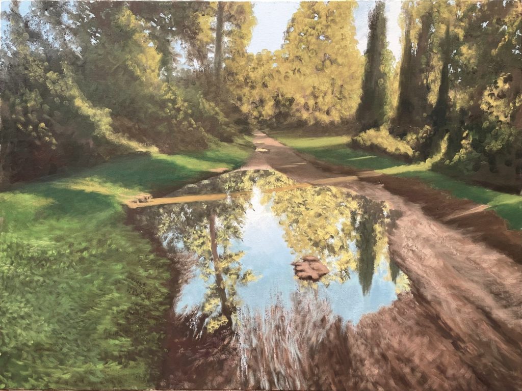 Yehuda Armoni painting of a sunlit dirt path between trees and green lawns, with a large puddle in the foreground reflecting the trees and the blue sky