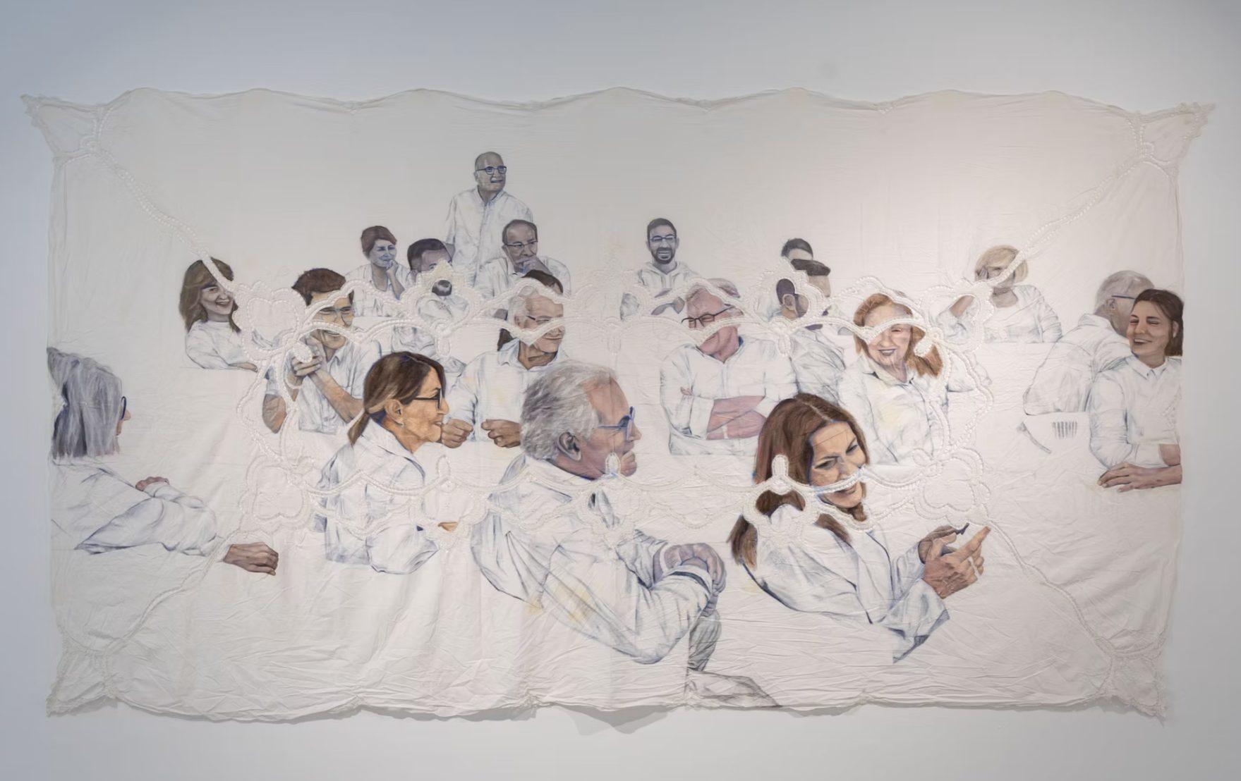 Chen Hefetz painting of a large multigenerational family seated together at a table, drawn in soft color on a white lace-edged tablecloth, faces turned toward one another and smiling