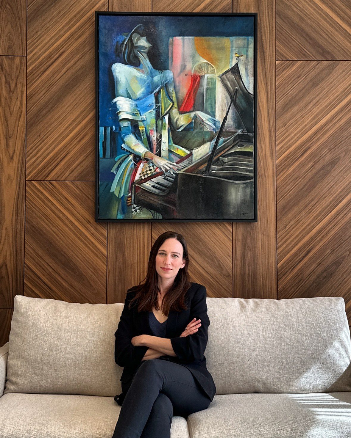 Stav Theodor seated on a couch beneath a large painting